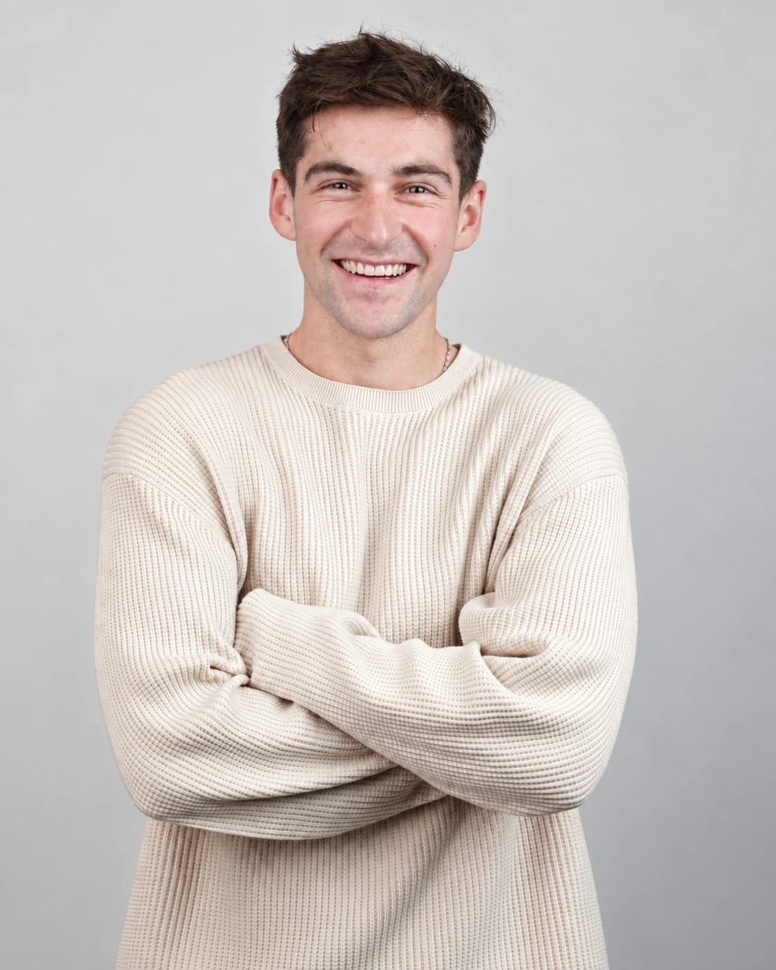Portrait of Roni Altshuler wearing a cream sweater against a gray background